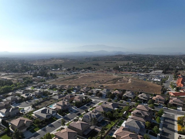 aerial view of property's location featuring a mountain backdrop and nearby suburban area
