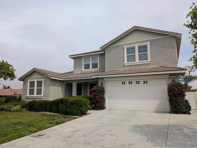traditional-style home featuring stucco siding, concrete driveway, an attached garage, a tiled roof, and a front yard