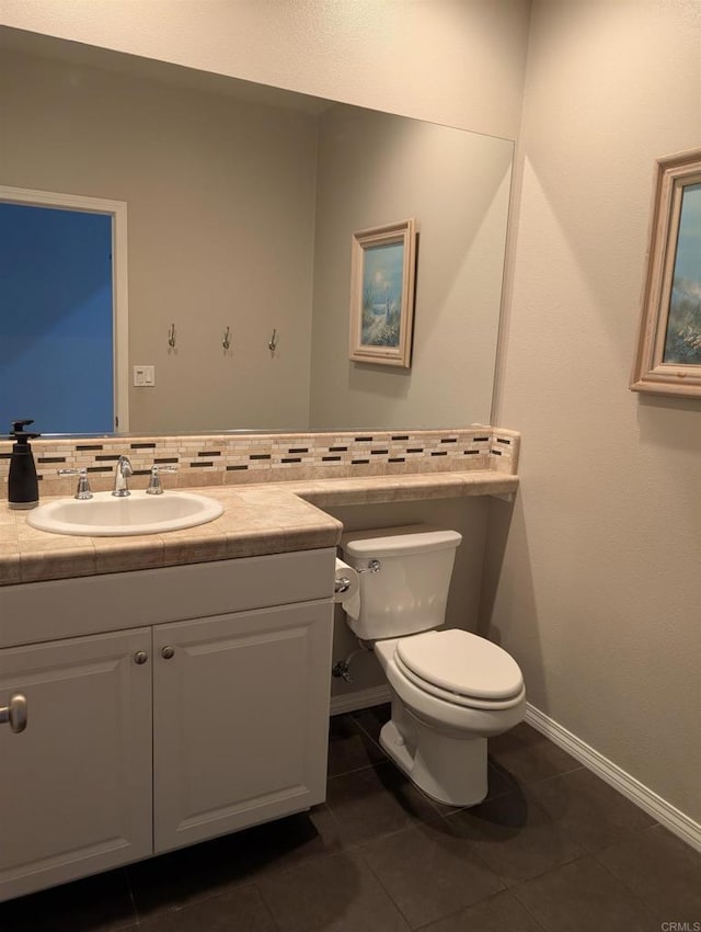 half bath with toilet, vanity, baseboards, tile patterned flooring, and backsplash