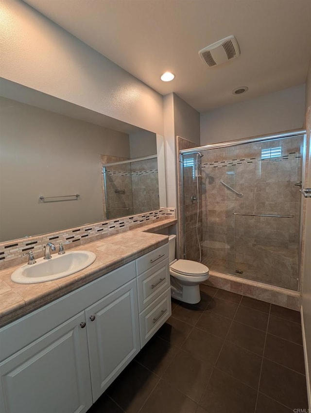 bathroom with a stall shower, vanity, toilet, tile patterned flooring, and recessed lighting