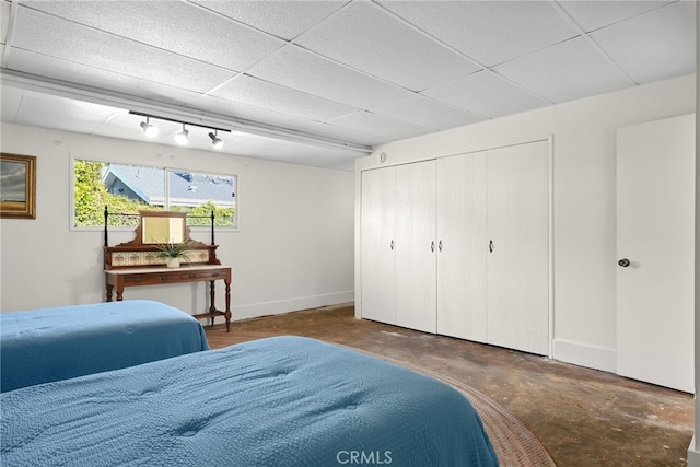 15731 Marlin Pl, Van Nuys, CA 91406 - bedroom featuring baseboards, a closet, a drop ceiling, and unfinished concrete floors