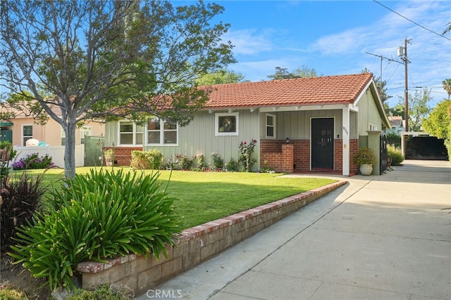 15731 Marlin Pl, Van Nuys, CA 91406 - single story home featuring board and batten siding, brick siding, a tile roof, and a front lawn