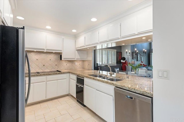 kitchen with a chandelier, white cabinets, tasteful backsplash, a sink, and appliances with stainless steel finishes