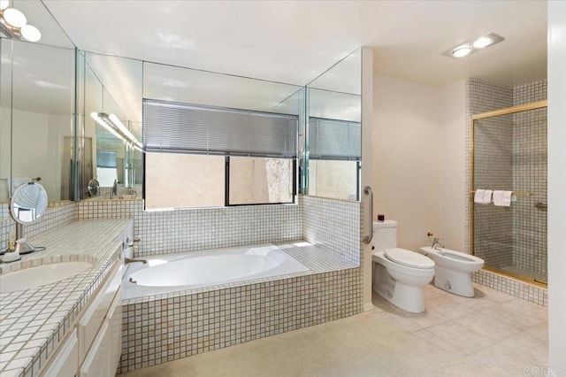 bathroom featuring vanity, a garden tub, a bidet, and a stall shower