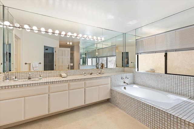 full bath featuring backsplash, double vanity, a sink, and a garden tub