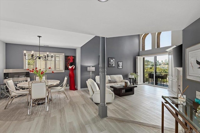 dining room featuring baseboards, a chandelier, plenty of natural light, and light wood-style floors