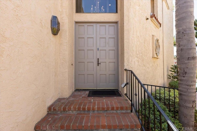 entrance to property featuring stucco siding