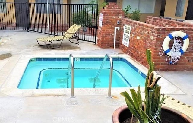 view of swimming pool featuring fence, a swimming pool, and a patio area