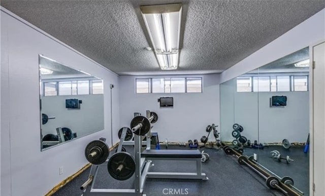 exercise room featuring a healthy amount of sunlight and a textured ceiling