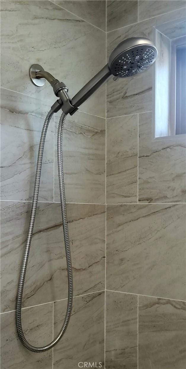 interior details featuring a tile shower