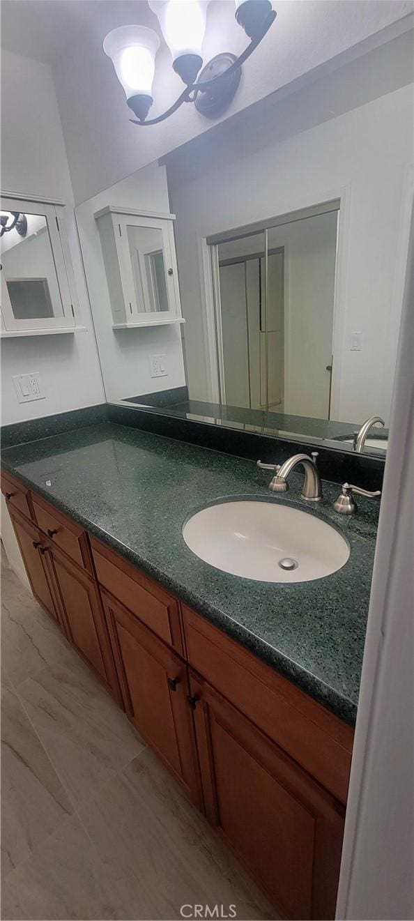 bathroom with vanity, marble finish floor, and a notable chandelier