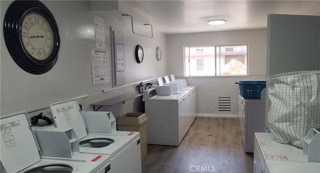 community laundry room with separate washer and dryer and light wood finished floors