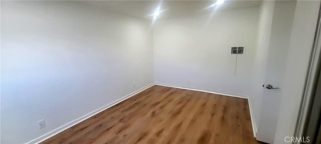 unfurnished room with baseboards and wood finished floors