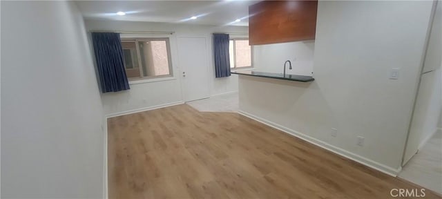interior space with baseboards and light wood finished floors