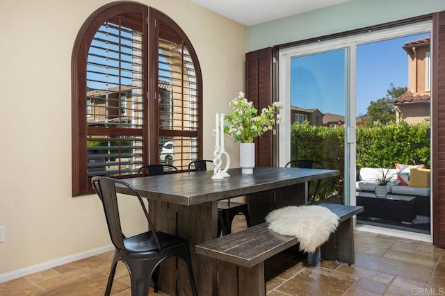 17011 Calle Trevino Unit 5, San Diego, CA 92127 - dining area featuring baseboards and stone tile floors
