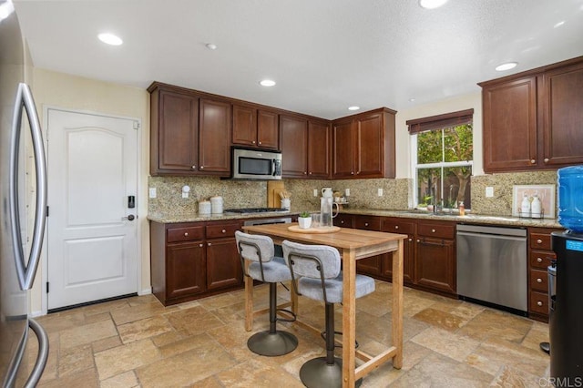 17011 Calle Trevino Unit 5, San Diego, CA 92127 - kitchen with backsplash, stainless steel appliances, light stone counters, and stone tile flooring