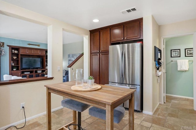 17011 Calle Trevino Unit 5, San Diego, CA 92127 - kitchen with freestanding refrigerator, recessed lighting, baseboards, visible vents, and stone tile flooring