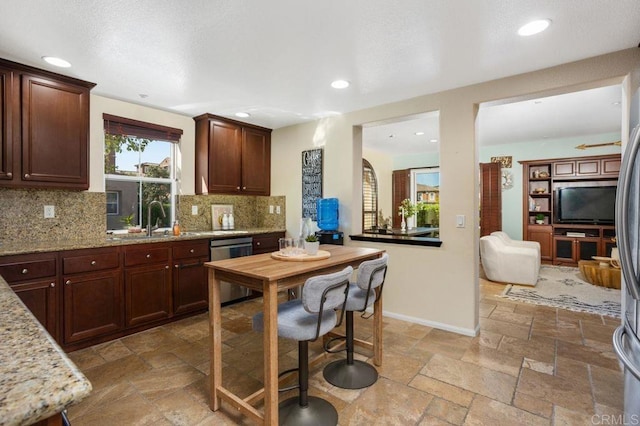17011 Calle Trevino Unit 5, San Diego, CA 92127 - kitchen with backsplash, dishwasher, a sink, light stone counters, and stone tile flooring