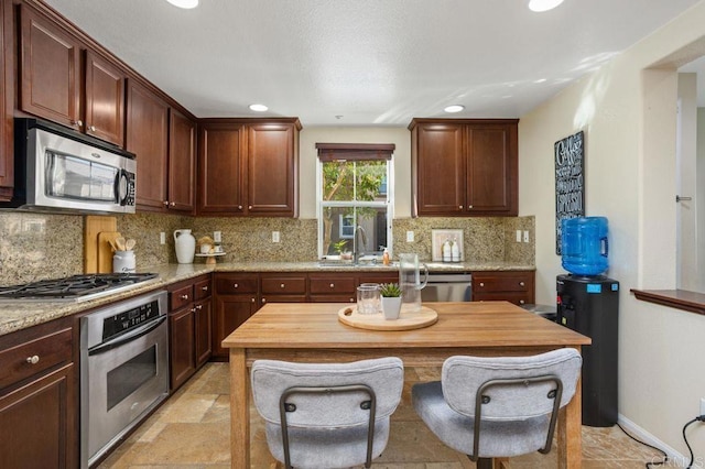 17011 Calle Trevino Unit 5, San Diego, CA 92127 - kitchen featuring recessed lighting, a sink, stone finish flooring, backsplash, and stainless steel appliances