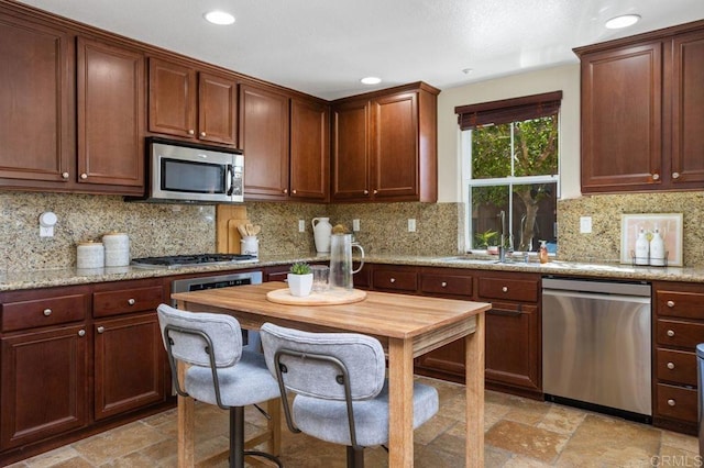 17011 Calle Trevino Unit 5, San Diego, CA 92127 - kitchen with a sink, appliances with stainless steel finishes, recessed lighting, and stone tile flooring