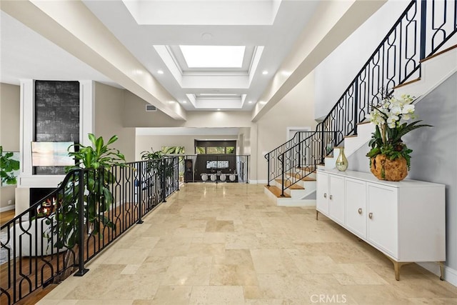 entrance foyer featuring stairs, stone finish flooring, baseboards, and visible vents