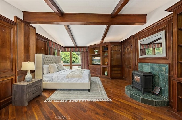 bedroom with vaulted ceiling with beams, a wood stove, and dark wood-type flooring