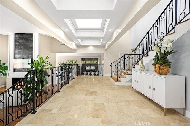 foyer entrance featuring baseboards, stone finish floor, stairs, and visible vents