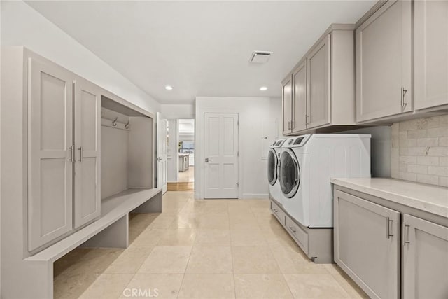 washroom with visible vents, light tile patterned flooring, recessed lighting, separate washer and dryer, and cabinet space