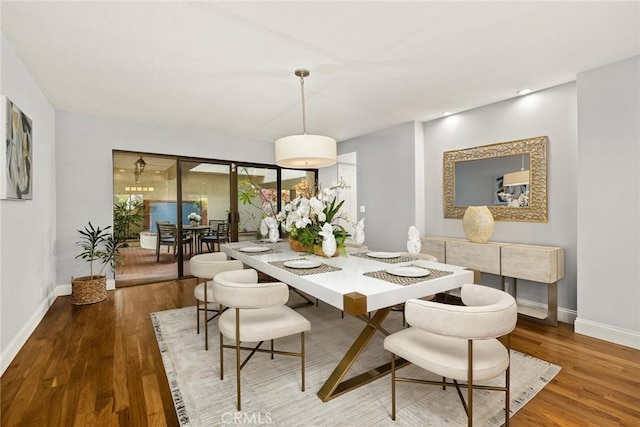 dining area with baseboards and wood finished floors