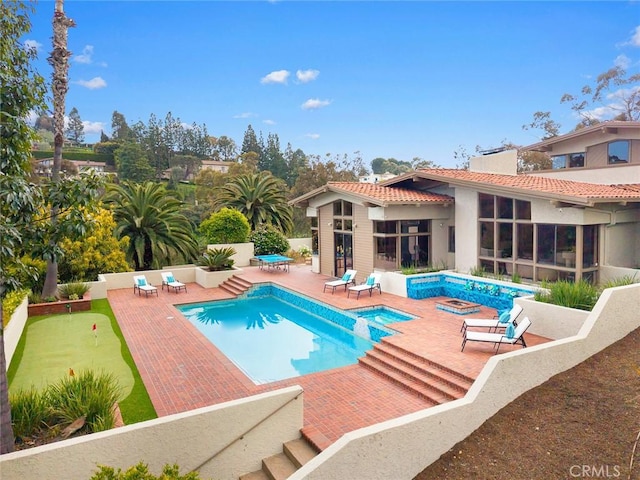 view of pool featuring a pool with connected hot tub and a patio area
