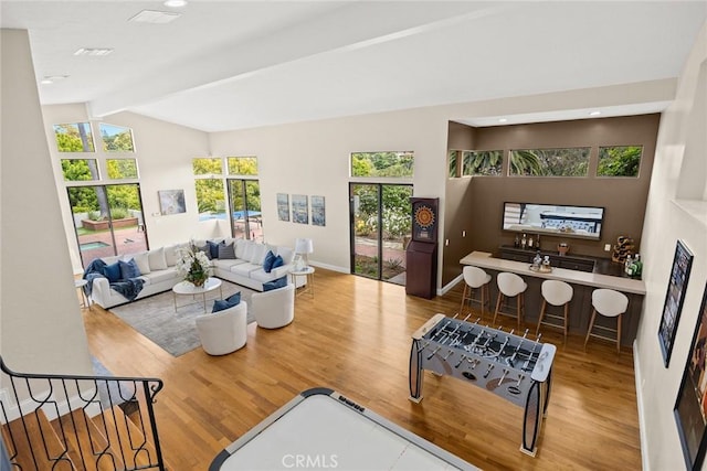 living area featuring visible vents, wood finished floors, baseboards, vaulted ceiling with beams, and recessed lighting