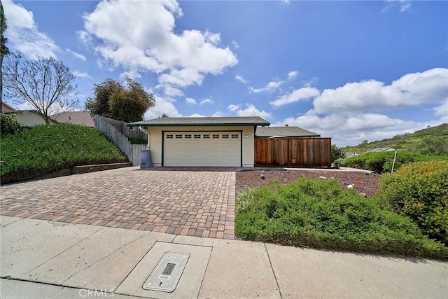 single story home featuring fence, stucco siding, decorative driveway, and a garage