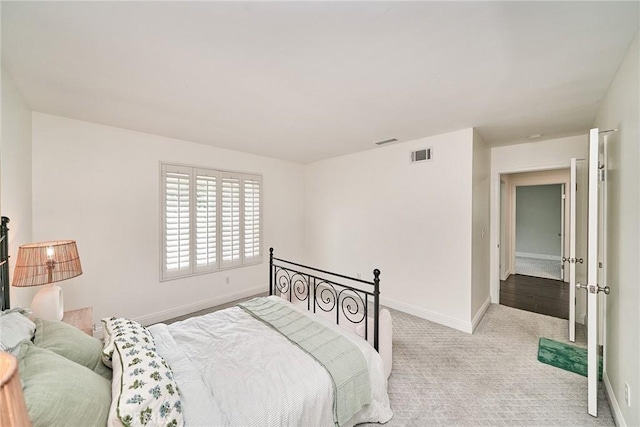 bedroom featuring baseboards, visible vents, and carpet