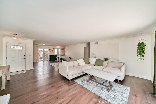 living area featuring crown molding, baseboards, dark wood-style floors, and visible vents