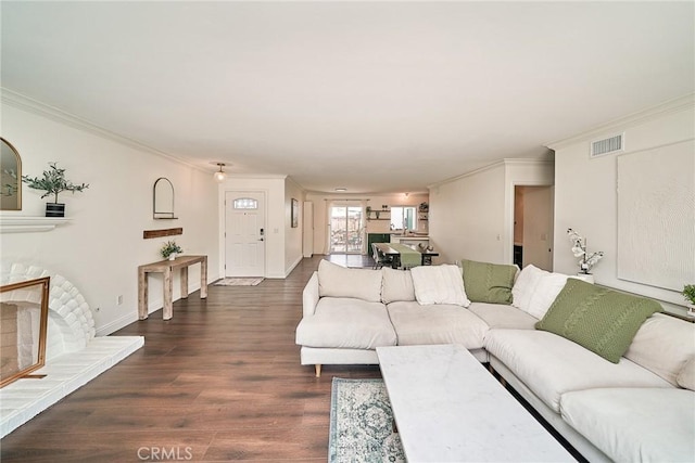 living room featuring baseboards, ornamental molding, dark wood-style floors, and visible vents