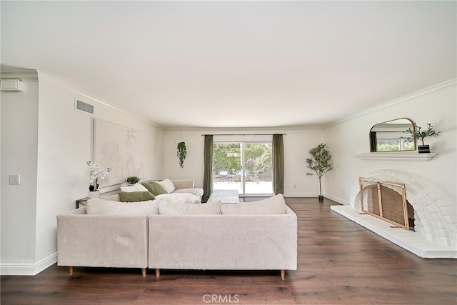 living area featuring visible vents, crown molding, wood finished floors, baseboards, and a fireplace with raised hearth