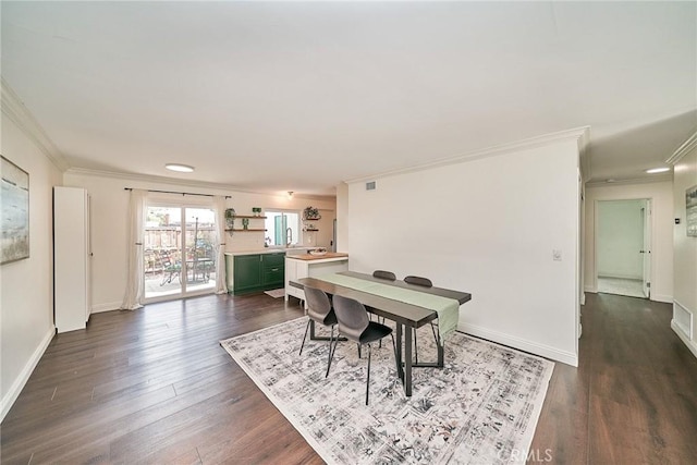 dining room with crown molding, dark wood-style flooring, and baseboards