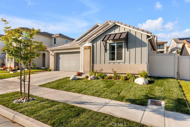view of front of house with board and batten siding, a front yard, fence, concrete driveway, and an attached garage