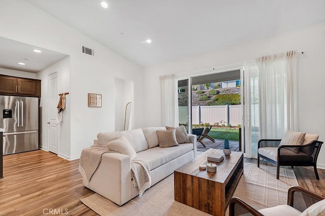 living area featuring recessed lighting, visible vents, lofted ceiling, and light wood-style floors