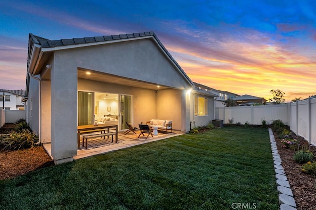 back of house featuring a patio area, an outdoor hangout area, a fenced backyard, a yard, and stucco siding
