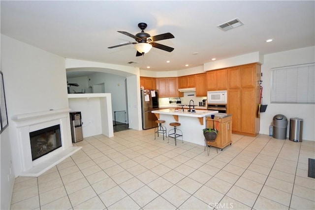 31105 Sunningdale Dr, Temecula, CA 92591 - kitchen featuring stainless steel appliances, a ceiling fan, light countertops, recessed lighting, and a kitchen bar