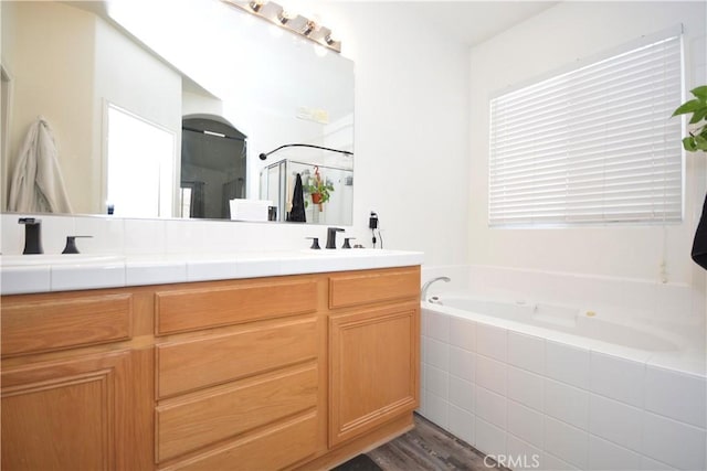 31105 Sunningdale Dr, Temecula, CA 92591 - bathroom featuring double vanity, a bath, a shower stall, and wood finished floors
