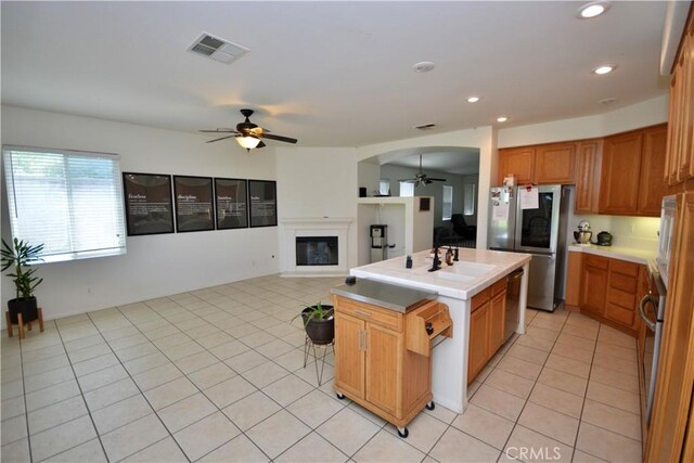 31105 Sunningdale Dr, Temecula, CA 92591 - kitchen with ceiling fan, stainless steel appliances, light tile patterned floors, a sink, and an island with sink