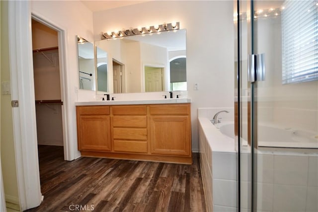 31105 Sunningdale Dr, Temecula, CA 92591 - bathroom featuring a garden tub, double vanity, a stall shower, and wood finished floors
