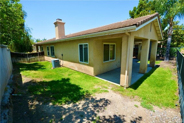 31105 Sunningdale Dr, Temecula, CA 92591 - back of property with cooling unit, a chimney, stucco siding, and a patio