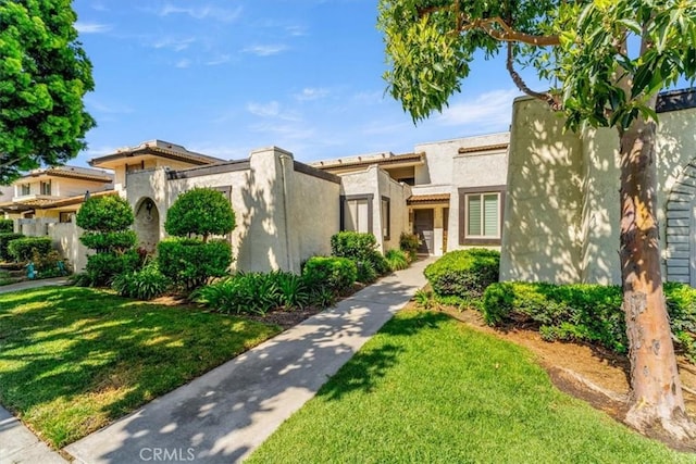 mediterranean / spanish-style house with stucco siding and a front lawn