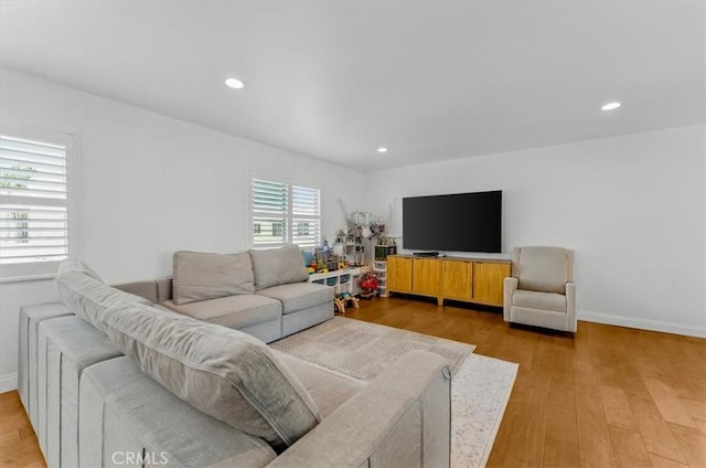living area with light wood-style floors, baseboards, and recessed lighting