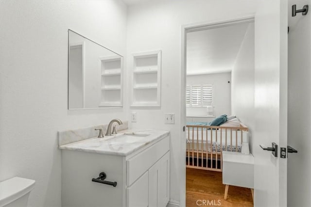 bathroom featuring vanity, wood finished floors, and toilet