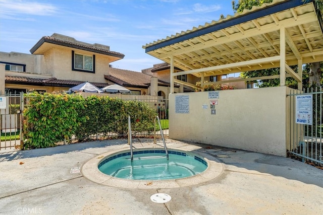 view of pool featuring a hot tub and fence