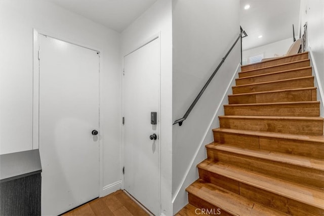 stairs with recessed lighting and wood finished floors